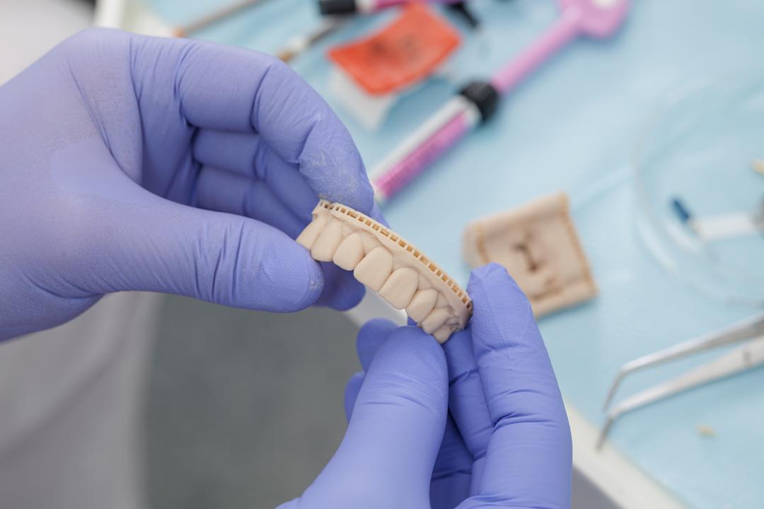 Dental technician examining a set of restoration crowns